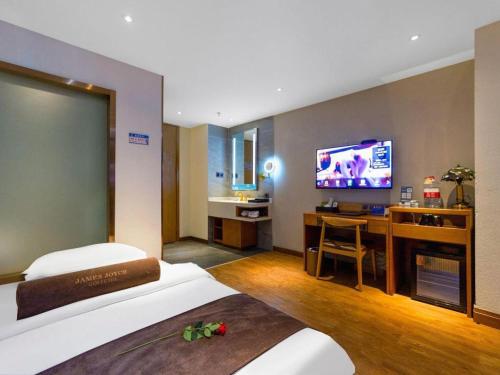 a hotel room with a bed and a flat screen tv at James Joyce Coffetel Xi'an Lingtong The Terracotta Army Huaqingchi University Town Metro Station in Xi'an