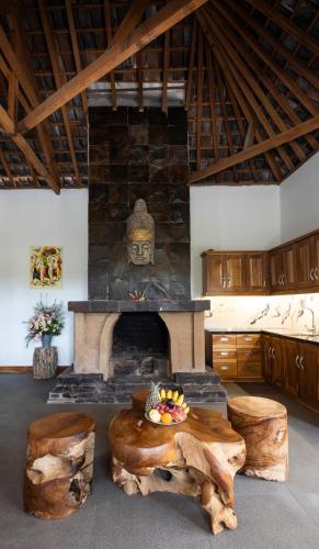 a living room with a stone fireplace with a statue at WiNy Kubu Reod in Sukasada