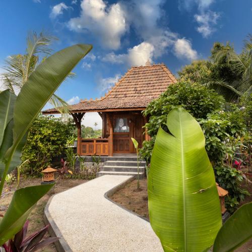 a house with a large green leaf in front of it at WiNy Kubu Reod in Sukasada
