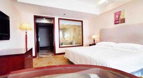 a bedroom with a bed and a television and a tub at Starmoon Hotel in Beijing