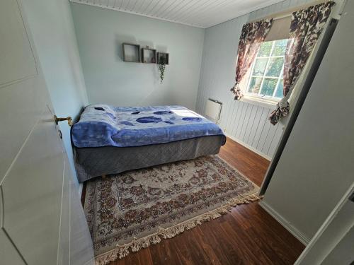 Un dormitorio pequeño con una cama y una alfombra. en Leilighet i Holmestrand, en Holmestrand