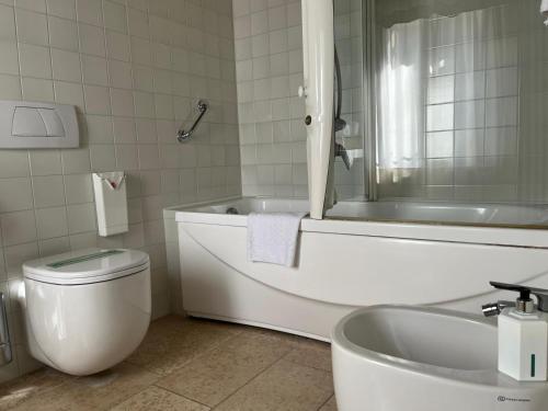 a bathroom with a tub and a toilet and a sink at Locanda La Candola in Farra di Soligo
