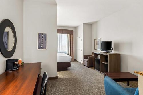 a hotel room with a bed and a desk and a room at Comfort Suites Waxahachie - Dallas in Waxahachie