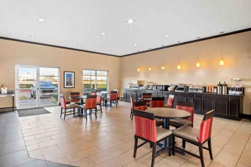 a restaurant with tables and chairs and a kitchen at Comfort Suites Waxahachie - Dallas in Waxahachie