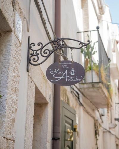 a sign hanging on the side of a building at Murantiche in Putignano