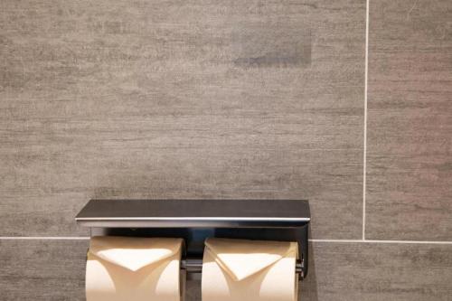 a black bench in front of a tile wall at Atour Hotel Weihai Shidao in Dongshan