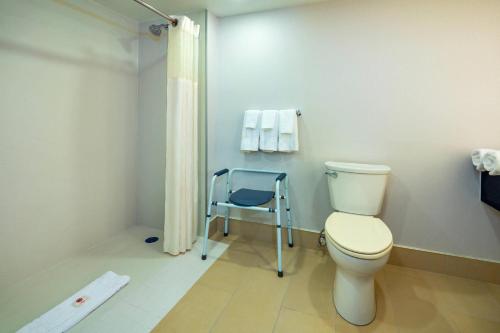 a bathroom with a toilet and a blue chair at Comfort Inn & Conference Centre Toronto Airport in Toronto
