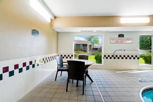 a dining room with a table and chairs and a pool at Comfort Inn South Tulsa - Woodland Hills in Tulsa