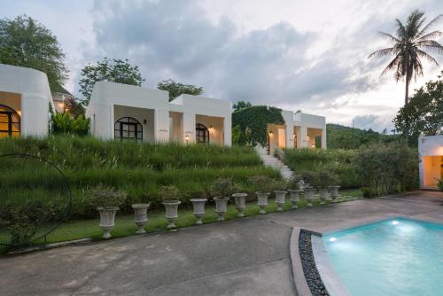 a house with a swimming pool in front of it at Villa La Flora Kaeng Krachan in Kaeng Krachan