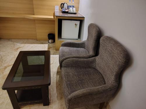 a living room with a chair and a table at LUXUS INN in Dhanbād