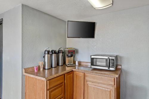 a kitchen with a counter with a microwave on it at Rodeway Inn Albuquerque West in Albuquerque