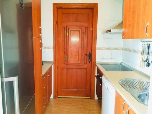 a kitchen with a wooden door and a sink at Casa Celeste with private pool in Mazarrón