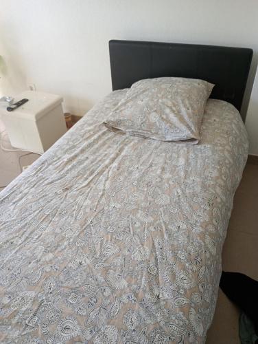 - un lit avec une couette blanche et un oreiller dans l'établissement Chambre 1 personne, à La Celle-sous-Gouzon