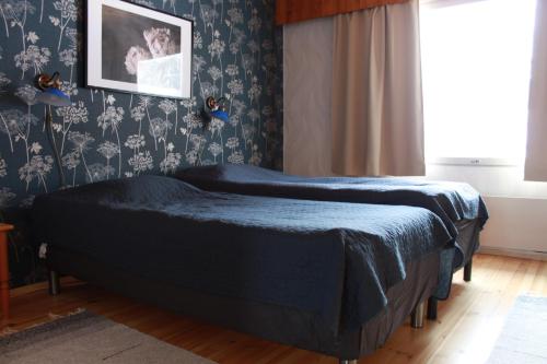 a bedroom with a bed with a blue blanket at Loma-Rantala Cottages in Tahkovuori