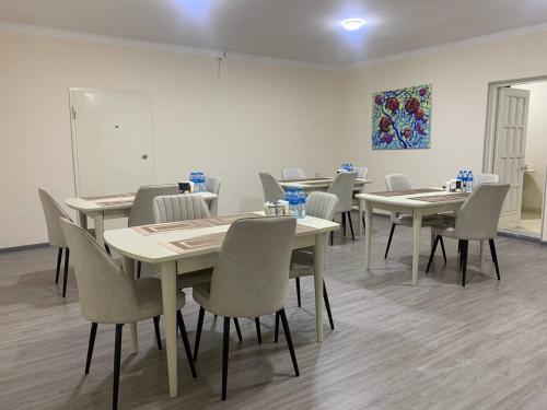 タシュケントにあるShams Artのテーブルと椅子があり、壁に絵が飾られた部屋