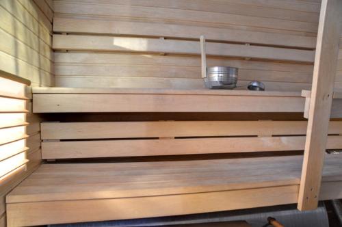 a wooden paneled sauna with a bowl on a shelf at Loma-Rantala Cottages in Tahkovuori
