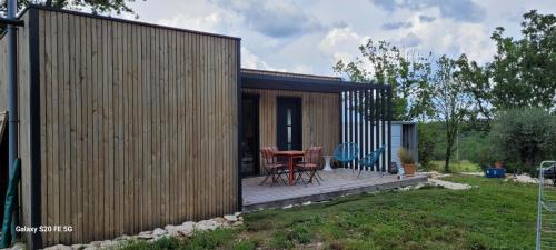 Cette petite cabine dispose d'une terrasse en bois avec une table. dans l'établissement TINY HOUSE Proche Cahors, à Le Montat