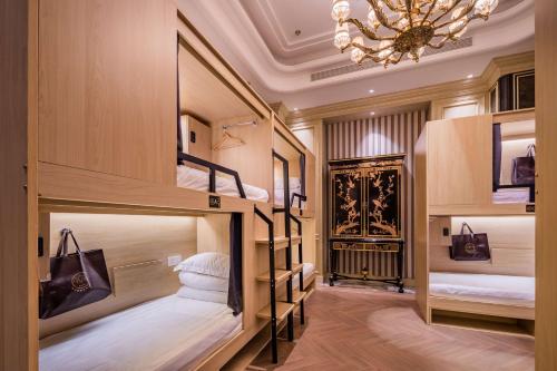 a room with three bunk beds with a chandelier at Eastern Paris Girls' Youth Hotel in Shanghai