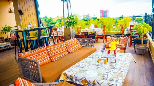 a restaurant with a bench and a table on a balcony at Millennium Terrace Hotel in Kampala