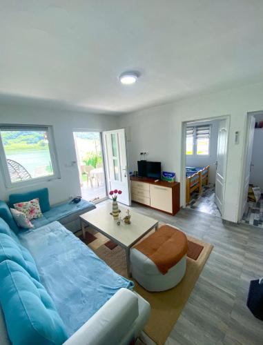 a living room with a blue couch and a table at Drina River Retreat in Novo Selo
