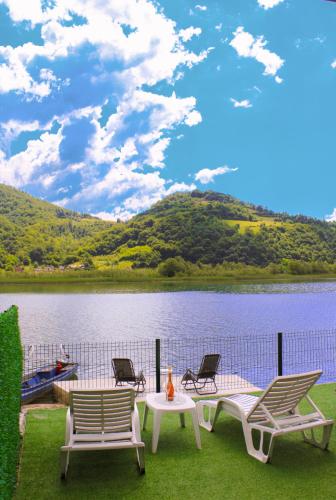 a group of chairs and a table next to a lake at Drina River Retreat in Novo Selo