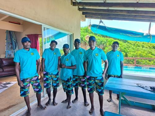 a group of men in blue shirts standing next to a pool at The View - Xai Xai Mozambique Xai Xai Beach Front 180 Degree Sea Views in Xai-Xai