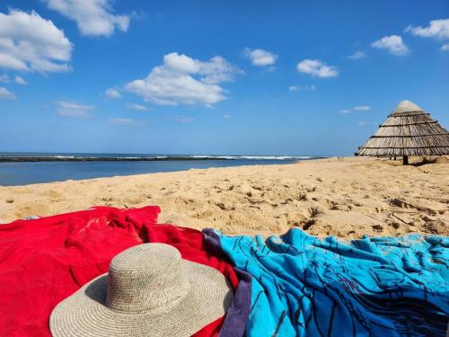 a hat sitting on a beach with clothes on it at The View - Xai Xai Mozambique Xai Xai Beach Front 180 Degree Sea Views in Xai-Xai