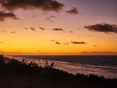 a sunset on the beach with the ocean at The View - Xai Xai Mozambique Xai Xai Beach Front 180 Degree Sea Views in Xai-Xai