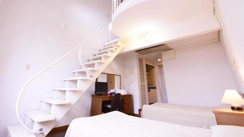 a white staircase in a bedroom with a bed at Petit Hotel Key West Club in Naha