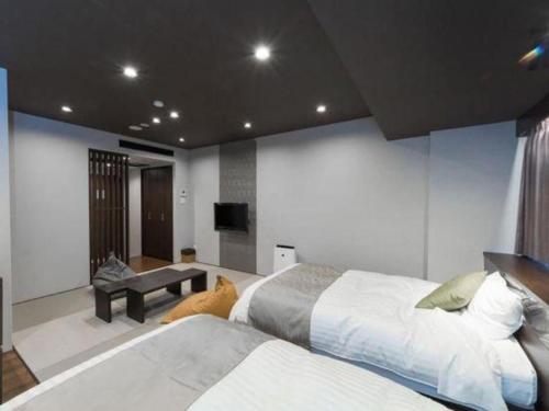 a bedroom with two beds and a flat screen tv at Centrale Hotel Kyotango in Kyotango