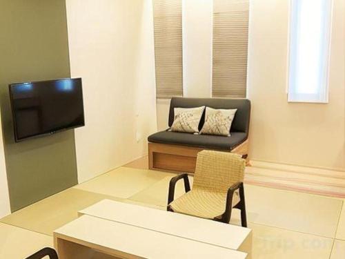 a living room with a couch and a chair at Centrale Hotel Kyotango in Kyotango