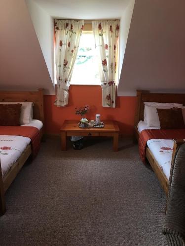 a attic room with two beds and a window at Heeneys Lodge B&B in Donegal