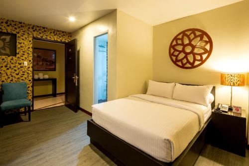 a bedroom with a bed and a blue chair at L Square Hotel in Tarlac
