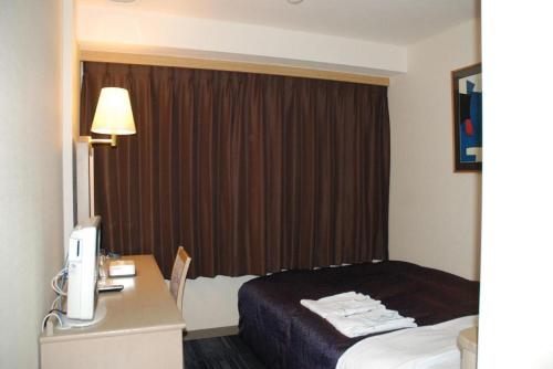 a hotel room with a bed and a desk at Albert Hotel in Akita