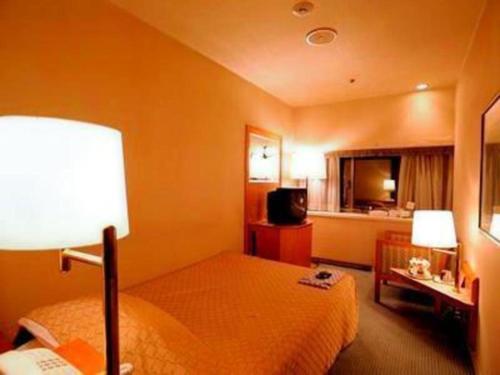 a hotel room with a bed and a kitchen at Gunma Royal Hotel in Maebashi