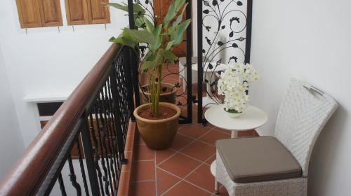 a balcony with a plant and a table and chair at Heeren Straits Hotel in Melaka