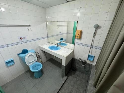 a bathroom with a blue toilet and a sink at Mega Inn Sri Aman in Simanggang