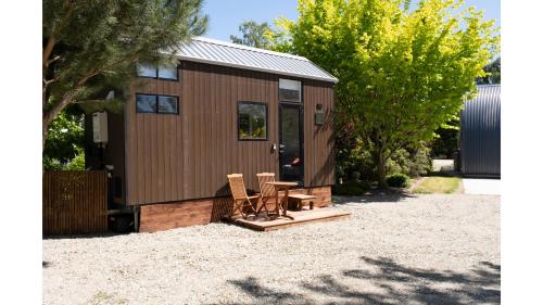 a tiny house with two chairs and a table at Tiny Away Benger Garden 1 by Tiny Away in Millers Flat
