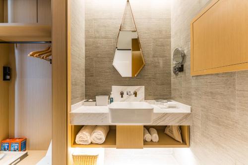 a bathroom with a sink and a mirror at Atour Hotel Suzhou Wangting in Suzhou
