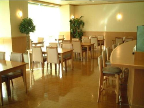 a dining room with wooden tables and chairs at Alpha Hotel Tokushima in Tokushima