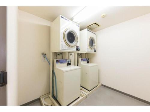 a room with two washer and dryers in a room at Alpha Hotel Tokushima in Tokushima