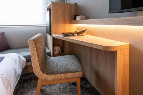 a room with a desk and a chair and a bed at Hotel Naito Kofu Showa in Kofu