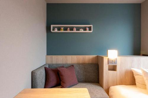 a room with a bed and a shelf on the wall at Hotel Naito Kofu Showa in Kofu