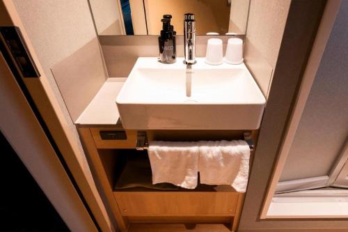 a bathroom with a sink and towels in it at Hotel Naito Kofu Showa in Kofu