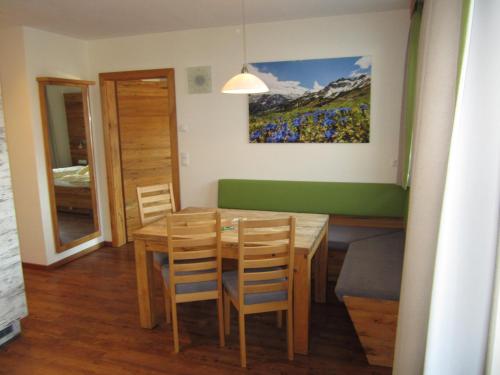 a dining room with a wooden table and chairs at Appartementhaus Gretzel in Wagrain