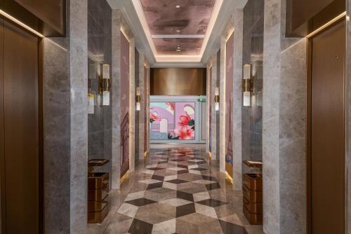 a hallway with a checkered floor in a hotel lobby at Mercure Guangzhou Financial City in Guangzhou