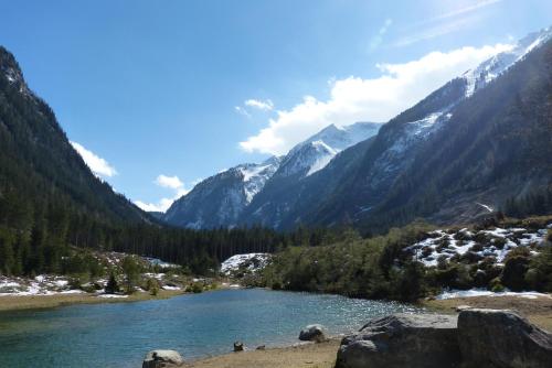 a river in a valley with snow capped mountains at Naturpension Mühlhof in Neukirchen am Großvenediger