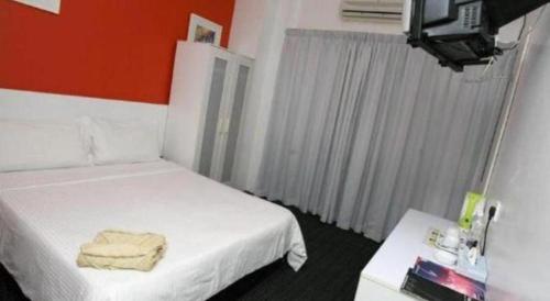 a hotel room with two beds and a television at Capital O Ridel Hotel Kota Bharu in Kota Bharu
