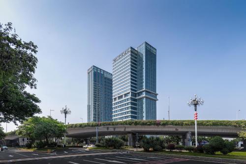 a parking lot with two tall buildings in the background at Mercure Guangzhou Financial City in Guangzhou