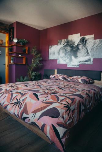 une chambre avec un grand lit aux murs violets dans l'établissement Suite romantique avec SPA, à Perpignan